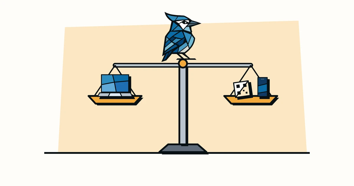 Jay the blue jay standing on top of a balance scale weighing a laptop against a QR tag and a phone